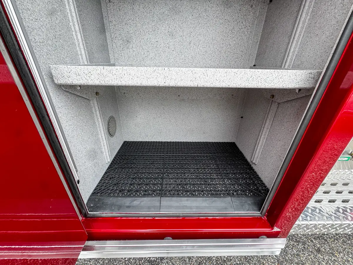 Deep side compartment interior close-up with wiring and textured liner.